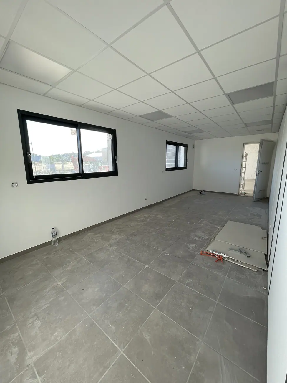 Bureaux rénovés : murs clairs et plafond suspendu